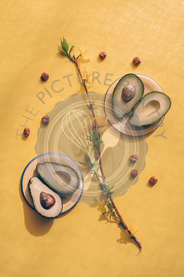 Fresh avocado on a yellow background with flowers