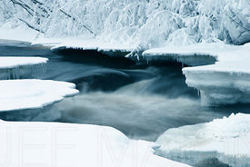Half-frozen river in snow