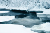 Half-frozen river in snow