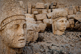 The west terrace of Mount Nemrut with heads of the colossal statues and the tumulus. Head of Antiochos1 in foreground with Commagene on left. The UNESCO World Heritage Site at Mount Nemrut where King Antiochus of Commagene is reputedly entombed.