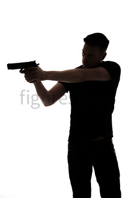 A Figurestock image of a man, in silhouette, pointing a gun – shot from eye level.