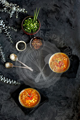 Bowls of Sesame Lentil Soup topped with roasted red peppers and chives.