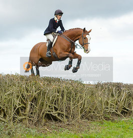 Katie Barber jumping a hedge near Gartree Covert