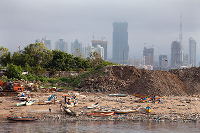 Garbage piles up near fishing boats in Mahim Bay, Mumbai, India. Mumbai's landfills are projected to fill up soon, with the massive Deonar dump, the largest in India, already holding 10 million tons.