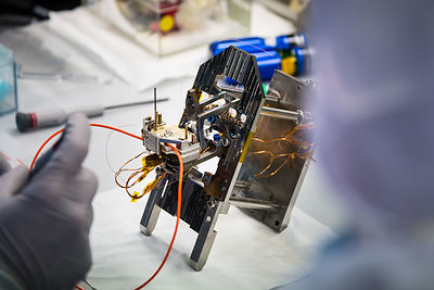 Montage du pivot et d'éléments d'un pendule du sismomètre ultrasensible SEIS Seismic Experiment for Interior Structures, dans une hotte à flux laminaire d'une salle blanche de l'entreprise Sodern.