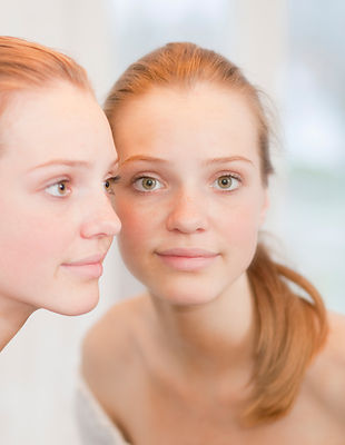 Teenage girl standing near mirror