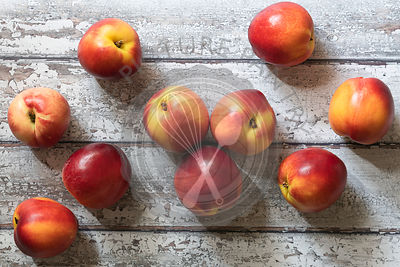 Red and yellow nectarines on wooden boards.