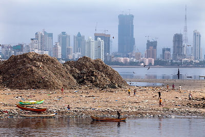 Garbage piles up near fishing boats in Mahim Bay, Mumbai, India. Mumbai's landfills are projected to fill up soon, with the massive Deonar dump, the largest in India, already holding 10 million tons.