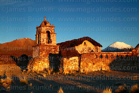 Rustic church near Lagunas just after sunrise, Parinacota volcano behind, Sajama National Park, Bolivia