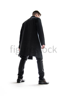 A Figurestock image of a mystery man standing, holding a gun – shot from low level.