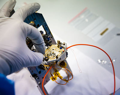 Montage du pivot et d'éléments d'un pendule du sismomètre ultrasensible SEIS Seismic Experiment for Interior Structures, dans une hotte à flux laminaire d'une salle blanche de l'entreprise Sodern.