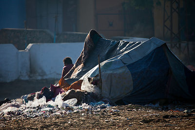 A mound of plastic trash outside a tent in a makeshift settlement, Pushkar, Rajasthan, India