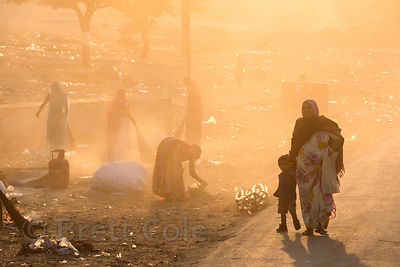 Women sweep up and burn garbage on a dusty desert road after the Pushkar Camel Fair, Pushkar, Rajasthan, India. Air pollution is an epidemic health crisis across India. India has the worst air pollution in the world, worse even than China, with Delhi the #1 worst city in the world.