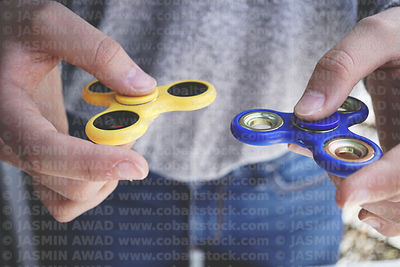 yellow_and_blue_fidget_spinners_two_hands_m8