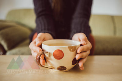 Woman's hands holding tea cup, close-up