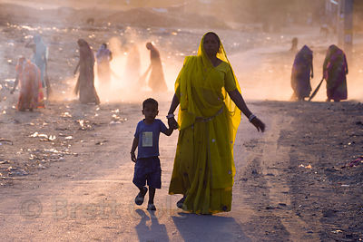 Women sweep up and burn garbage on a dusty desert road after the Pushkar Camel Fair, Pushkar, Rajasthan, India. Air pollution is an epidemic health crisis across India. India has the worst air pollution in the world, worse even than China, with Delhi the #1 worst city in the world.