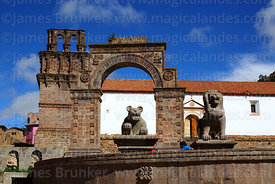 Puma and lion statues in plaza in front of entrance archway and Nuestra Señora de la Asunción church, Juli, Puno Region, Peru