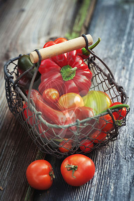 Home-grown sweet peppers and tomatoes on a wooden background