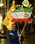 Amsterdam, Netherlands 2015-01-08: Man carrying two flags at the demonstration of support for Charlie Hebdo.