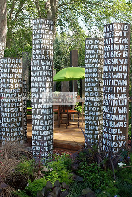 Coin repas au potager. Décoration insolite : Colonne, Table, chaise, parasol. Designer : Paul Stone. Chelsea FS, Angleterre