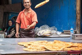 Baker throwing arab round bread , Xinjiang, China