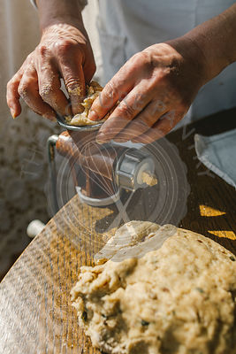 Woman Preparing Homemade Dough in the Kitchen and using a mincing machine. Preparation Raw Dough for Baking