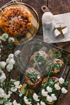 Baked stuffed potatoes with cheese, vegetables, sour cream and rucola on wooden table. Top view