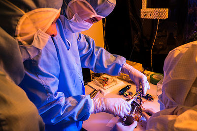 Ingénieurs assemblent le pivot et des éléments d'un pendule du sismomètre ultrasensible SEIS Seismic Experiment for Interior Structures, dans une hotte à flux laminaire d'une salle blanche de l'entreprise Sodern.