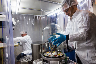 Ingénieurs préparent un sismomètre SEIS pour un test sous vide dans caisson de simulation d'ambiance martienne sous hotte à flux laminaire. Pilier sismique de la cave sismique de IPGP Institut de Physique du Globe de Paris.