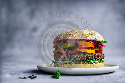 Vegan Mexican black bean and quinoa burger on sesame bun with lime and picked onions