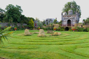 Oberon's Palace, a copy in oak of an Inigo Jones' design for a royal masque performed in Whitehall in 1611, recreated in the Collector Earl's Garden, designed by Julian and Isabel Bannerman. It sits atop a rockwork mountain and is surrounded by strongly architectural planting including palms, fatsias and cordylines. Arundel Castle Gardens, Arundel, West Sussex, UK