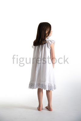 A Figurestock image of a little girl, standing in a night dress, looking away – shot from eye level.