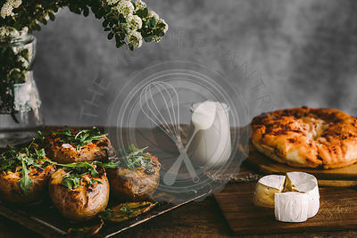 Baked stuffed potatoes with cheese, vegetables, sour cream and rucola on wooden table Rustic background. Copy space