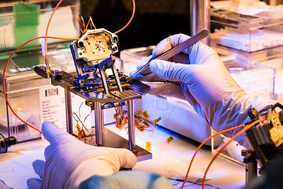 Montage du pivot et d'éléments d'un pendule du sismomètre ultrasensible SEIS Seismic Experiment for Interior Structures, dans une hotte à flux laminaire d'une salle blanche de l'entreprise Sodern.