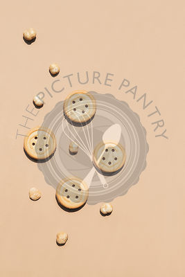 Round walnut cookies on a caramel coloured background.