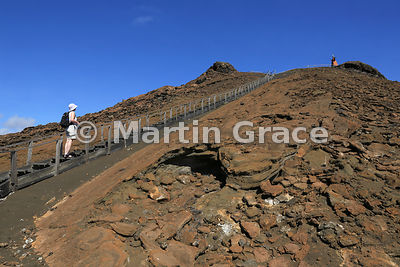 Tourist on the wooden steps to the summit viewpoint of Bartolome Island, Galapagos Islands