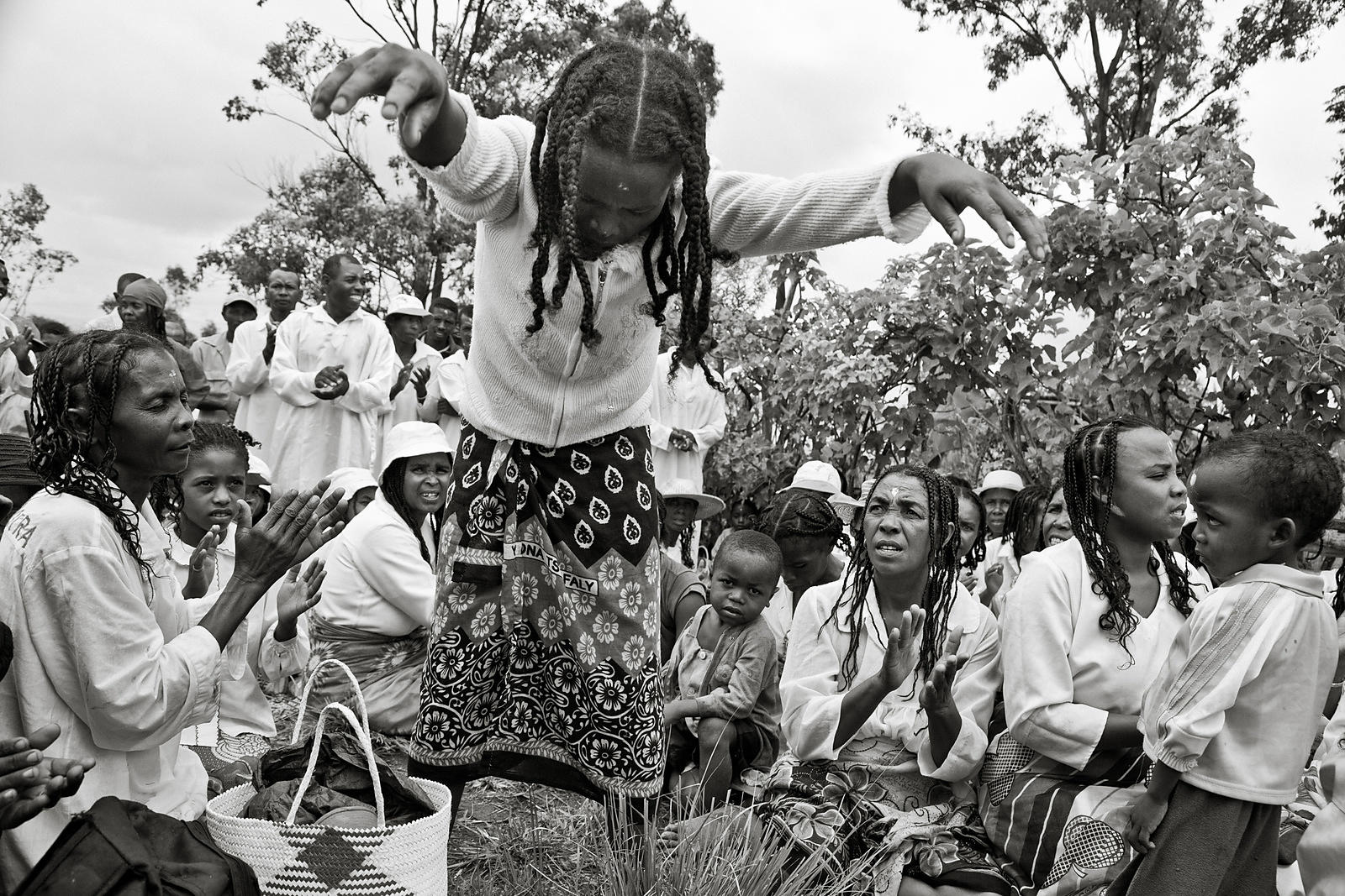 MANGALAZA COMMUNE - "Mpanazary" in the middle of a trans session. They are members of the ANTALAOTRA association, the largest cultural association in this part of Madagascar, whose mission is to promote and make known the rites, cults and traditions of the Alaotra Mangoro region, a sacred region according. Created in 2014, the association already has 37,000 members. Most of them are Mpanazary that can be translated as spiritual guide, diviner, medium. The literal translation is "bewitching". The Mpanazary are almost considered as " demi-gods ". Their dreams, predictions and premonitions are respected and followed by the people of the region and even by the civil and administrative authorities. The region around Lake Alaotra (North-East of Madagascar) is one of the richest agricultural regions in Madagascar. It is considered the "rice granary" of the Big Island. Some argue without hesitation that it is because of the sacred character of the region and its particular cultural practices that the region is so prosperous. Today, as every year, the local population and some Mpanazary go to a sacred hill near the village of Mangalaza to invoke the spirits of the ancestors (Tromba) and ask Zanahary (animist Malagasy God) and Andriamanitra (Christian God) to kindly bring again the beneficial rains for next October that will grow the crops. Each Mpanazary has its specialty: some can bring rain, some can stop cyclones, others can drive out evil spirits. The patients take the opportunity to be treated by the Mpanazary-healer. .