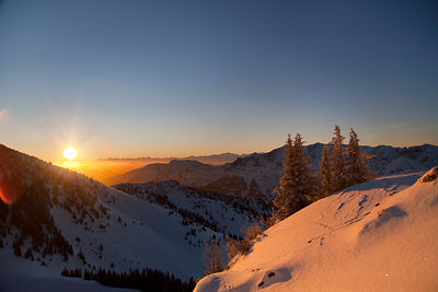 Sun setting over snowy landscape