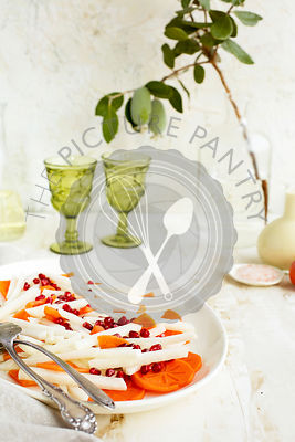 Jicama Persimmon Pomegranate Salad with Guava Chevre Vinaigrette. Photographed on a rustic white background.