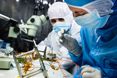 Ingénieurs assemblent le pivot et des éléments d'un pendule du sismomètre ultrasensible SEIS Seismic Experiment for Interior Structures, dans une hotte à flux laminaire d'une salle blanche de l'entreprise Sodern.