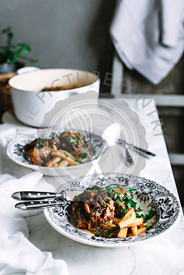Oxtail casserole and chips on a rustic kitchen table