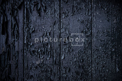 A background textured image of burnt wood.