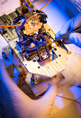 Montage du pivot et d'éléments d'un pendule du sismomètre ultrasensible SEIS Seismic Experiment for Interior Structures, dans une hotte à flux laminaire d'une salle blanche de l'entreprise Sodern.