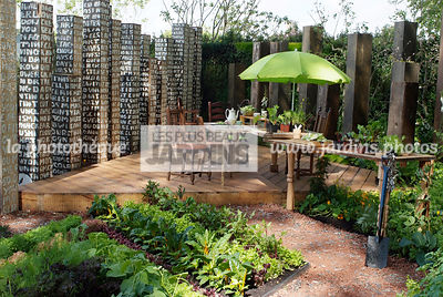 Potager biologique. Terrasse en bois. Mobilier de jardin : table, chaise, parasol. Designer : Paul Stone. Chelsea FS, Angleterre
