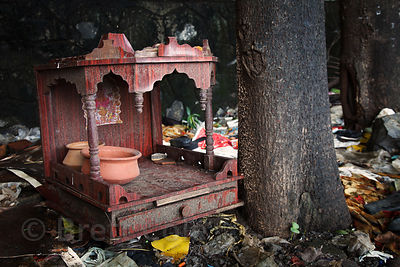 A small wooden Hindu altar sits on a garbage pile in the Dharavi slum, Mumbai, India.
