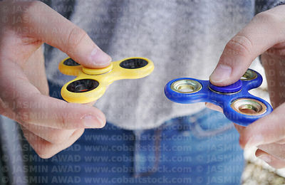 teenage_hands_with_two_fidget_spinners