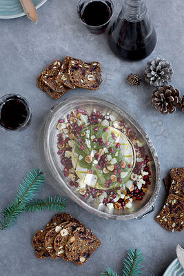 Baked Camembert with Gorgonzola Hazelnut Pesto served with red wine and crackers.