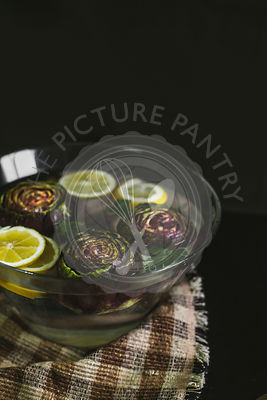 Artichokes in water with lemons for flavouring
