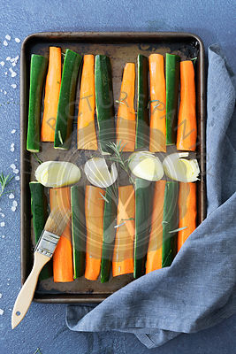 Raw carrot, zuchinni and leek on a baking tray ready for roasting.