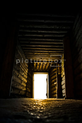 An atmospheric, low perspective image of a darkly lit underground tunnel / bunker.